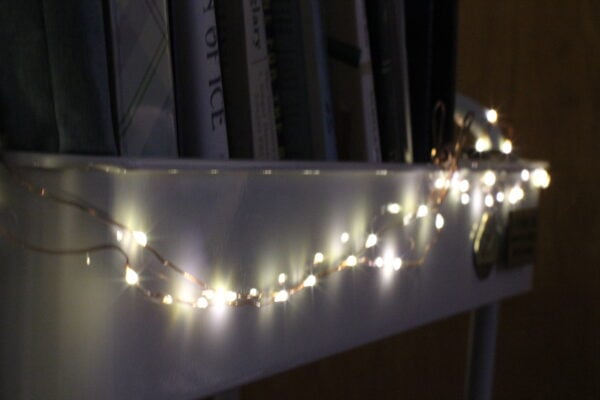 A string of white twinkle lights shot with a shallow depth of field so only the closest are in focus.